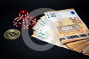 Bitcoin coin, a pile of Euro banknotes and a few red cubes lie side by side on a dark background