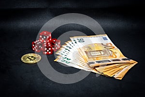 Bitcoin coin, a pile of Euro banknotes and a few red cubes lie side by side on a dark background