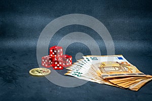 Bitcoin coin, a pile of Euro banknotes and a few red cubes lie side by side on a dark background