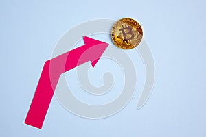 Bitcoin coin and red arrow pointing up, cryptocurrency rate concept