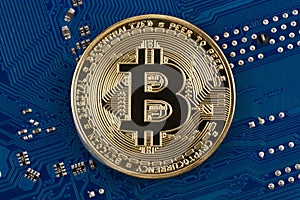 Bitcoin coin symbol face side on blue electronic circuit board background. Close-up, blue background