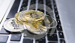 Bitcoin coin on a top of other crypto coins on a keyboard of laptop. Bitcoin golden coins. Cryptocurrency investment