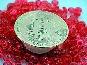 Bitcoin coin on top of red beats