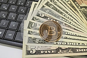 Bitcoin coin with US dollars and computer keyboard