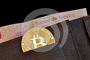 Bitcoin coin in a wallet leather and mexican banknote, bank of mexico pesos out of focus