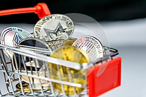 Bitcoin coins and altcoins in a shopping cart photo