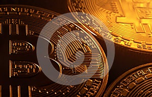 Bitcoin coins on a black background with golden highlights. Cryptocurrency market