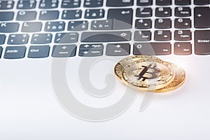 Bitcoin coins on a keyboard of white laptop. Computer. Investment situation. New virtual currency. Most valuable cryptocurrency