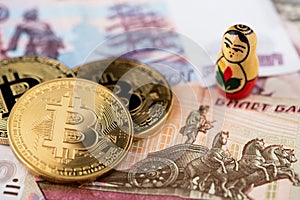 Bitcoin coins on Russian banknotes with russian national doll A close up image of bitcoins with Russian rubles banknotes.