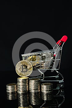 Bitcoin coins in shopping cart on black background