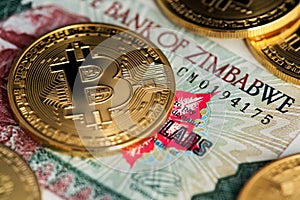 Bitcoin coins on Zimbabwe banknote. A close up image