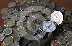Bitcoin on a compass lying on a pile of Euro coins photo