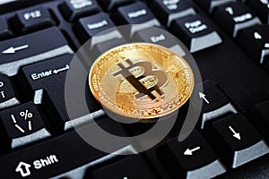 Bitcoin on compuer keyboard in background, symbol of electronic virtual money and mining cryptocurrency concept. Coin crypto