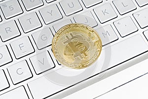 Bitcoin crypto currency. Gold bitcoin and computer keyboard. Golden digital cryptocurrency coin. Electronics finance money symbol