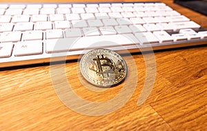 Bitcoin cryptocurrency coin on the background of the computer keyboard