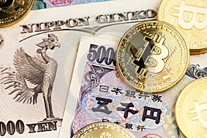 Bitcoin Cryptocurrency coins on Japanese Yen banknotes.