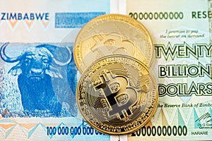 Bitcoin Cryptocurrency coins and Zimbabwe hyperinflation banknote photo