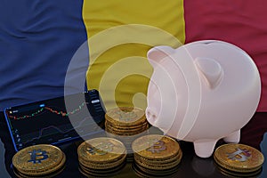 Bitcoin and cryptocurrency investing. Chad flag in background. Piggy bank, the of saving concept. Mobile application for trading