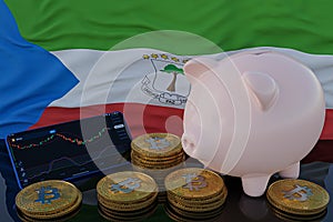 Bitcoin and cryptocurrency investing. Equatorial Guinean flag in background. Piggy bank, the of saving concept. Mobile application