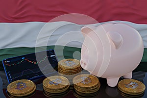 Bitcoin and cryptocurrency investing. Hungary flag in background. Piggy bank, the of saving concept. Mobile application for