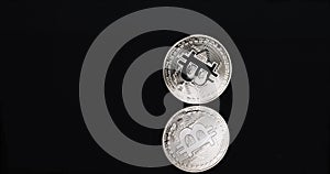 Bitcoin cryptocurrency spinning on black background with reflection