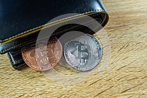 Bitcoin digital currency instead real money, bit-coin with leather wallet or purse on wooden working table, virtual