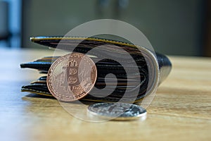 Bitcoin digital currency instead real money, bit-coin with leather wallet or purse on wooden working table, virtual