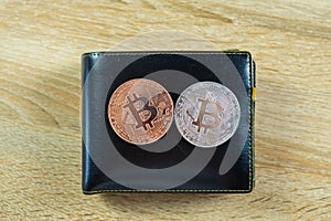 Bitcoin digital currency instead real money, bit-coin with leather wallet or purse on wooden working table, virtual