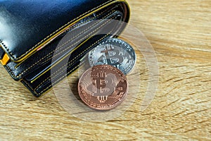 Bitcoin digital currency instead real money, bit-coin with leather wallet or purse on wooden working table, virtual