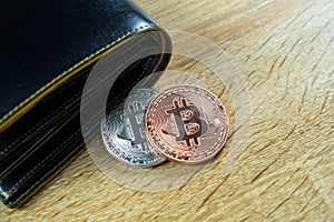 Bitcoin digital currency instead real money, bit-coin with leather wallet or purse on wooden working table, virtual