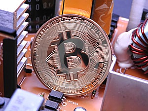 Bitcoin in front of electronic parts and coolers