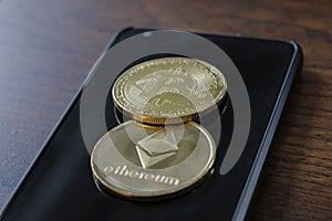 A bitcoin and etherium token on a cell phone