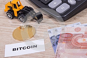 Bitcoin, euro bills, miniature excavator and calculator. Cryptocurrency. International network payment. Finance concept