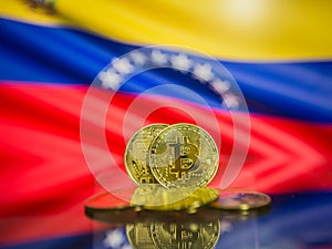 Bitcoin gold coin and defocused flag of Venezuela background. Virtual cryptocurrency concept.
