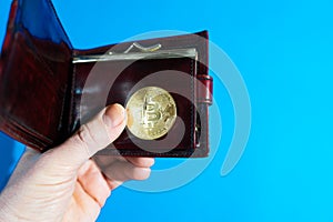 Bitcoin gold coin in leather wallet.