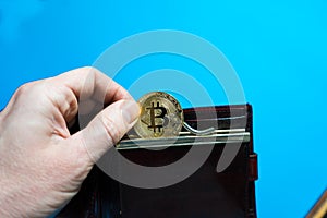 Bitcoin gold coin in leather wallet.