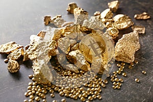 Bitcoin and gold nuggets on table