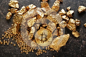 Bitcoin and gold nuggets on table