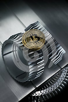 Bitcoin golden coin lies on the gearwheel.