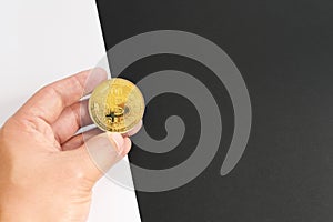 Bitcoin halving concept in cryptocurrency. Hand holding coin in black and white background.