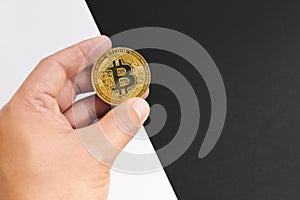 Bitcoin halving concept in cryptocurrency. Hand holding coin in black and white background.