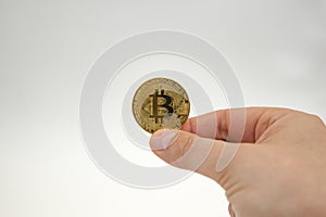 bitcoin in hand, female hand holds a gold bitcoin coin. Cryptocurrency value, digital money, space for text,copy space