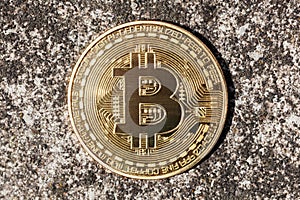 Bitcoin logo, round metal gold crypto coin, cryptocurrency representative symbol on concrete background, closeup