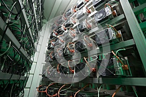 Bitcoin miners in large farm. ASIC mining equipment on stand racks mine cryptocurrency in steel container. Blockchain