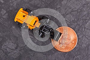 Bitcoin and miniature excavator, symbol of electronic virtual money and mining cryptocurrency