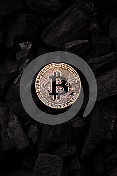 Bitcoin mining concept. Bitcoin cuurency on charcoal