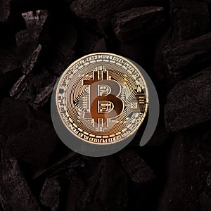 Bitcoin mining concept. Bitcoin cuurency on charcoal