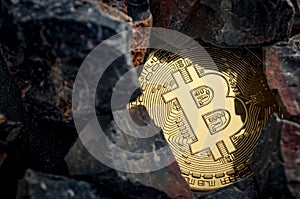 Bitcoin mining and cryptocurrency concept with a golden coin submerged in black stones compared to the traditional gold mining