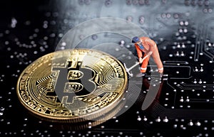 Bitcoin mining miniature worker, small figure holding mattock di