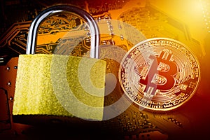 Bitcoin with padlock on computer motherboard. Crypto currency Internet data privacy information security concept. Focus on bitcoin